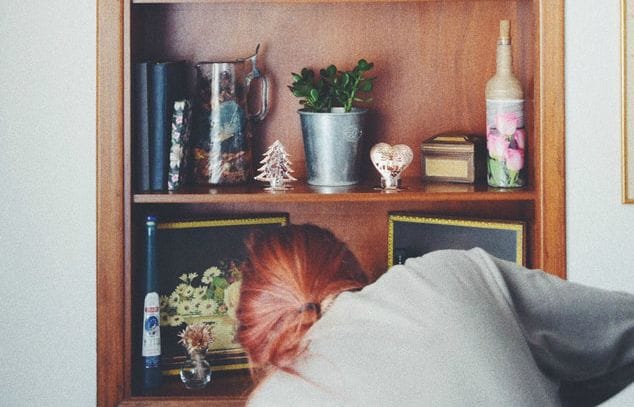 Woman Cleaning Book Shelf | 3GuysMoving.com